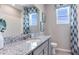 Well-lit bathroom features a granite countertop, modern fixtures, and coordinated blue and white accents at 804 157Th E Ct, Bradenton, FL 34212