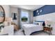 Comfortable bedroom with a blue accent wall, natural light, and contemporary decor at 808 157Th E Ct, Bradenton, FL 34212