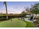 This backyard has a putting green, artificial grass, a seating area with fire pit and hedges at 8258 Midnight Pass Rd, Sarasota, FL 34242
