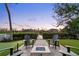 Cozy backyard with a fire pit, comfortable Adirondack chairs, manicured lawn and a peek at the waterfront at 8258 Midnight Pass Rd, Sarasota, FL 34242