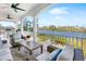 Relaxing covered balcony with comfortable seating overlooking the water at 8258 Midnight Pass Rd, Sarasota, FL 34242