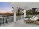 Spacious outdoor balcony with white columns and railings and a seating area with chaise lounges at 8258 Midnight Pass Rd, Sarasota, FL 34242