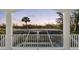 Balcony view showcasing a screened-in pool area surrounded by lush landscaping with a water view at 8258 Midnight Pass Rd, Sarasota, FL 34242