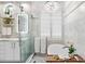 Well-lit bathroom featuring a tub under a chandelier and a glass shower at 8258 Midnight Pass Rd, Sarasota, FL 34242