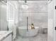Beautiful bathroom with soaking tub under a chandelier, and white marble detail at 8258 Midnight Pass Rd, Sarasota, FL 34242