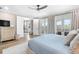 Bright bedroom featuring a ceiling fan, hardwood floors, and access to a private balcony with great outdoor views at 8258 Midnight Pass Rd, Sarasota, FL 34242