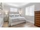 Well-lit bedroom featuring a comfortable bed with a tufted headboard and soft gray bedding at 8258 Midnight Pass Rd, Sarasota, FL 34242