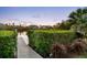 A dock leading to the water, surrounded by lush greenery and views of nearby houses at 8258 Midnight Pass Rd, Sarasota, FL 34242