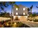 Elegant home features a two-car garage, well-lit driveway, mature landscaping, and a stately facade at 8258 Midnight Pass Rd, Sarasota, FL 34242