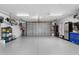 A spacious garage with gray epoxy flooring, bright lighting, and an insulated door at 8258 Midnight Pass Rd, Sarasota, FL 34242