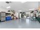 Spacious garage with storage cabinets, blue toolbox, and bikes; well-lit with gray floor at 8258 Midnight Pass Rd, Sarasota, FL 34242