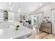 Bright kitchen with island, marble countertops and an open flow to the sitting and dining areas at 8258 Midnight Pass Rd, Sarasota, FL 34242