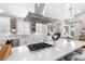 Modern kitchen with stainless steel hood, marble countertops, backsplash and pendant lighting at 8258 Midnight Pass Rd, Sarasota, FL 34242
