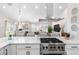 Gourmet kitchen with stainless steel range and hood flows into the dining and living areas at 8258 Midnight Pass Rd, Sarasota, FL 34242