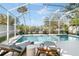 Screened-in pool with lounge chairs, offering a serene outdoor living space with lush greenery at 8258 Midnight Pass Rd, Sarasota, FL 34242