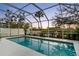 A screened-in pool area with outdoor seating, a putting green, and lush greenery at 8258 Midnight Pass Rd, Sarasota, FL 34242