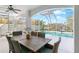 Screened in pool area with spiral staircase, and outdoor dining space with seating for six at 8258 Midnight Pass Rd, Sarasota, FL 34242