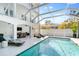 Screened-in pool with connected patio, lounge chairs, and spiral staircase in a well lit outdoor living space at 8258 Midnight Pass Rd, Sarasota, FL 34242