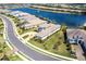 Stunning aerial view of a modern home with a lake view, lush landscaping, and a curved driveway at 8265 Pavia Way, Bradenton, FL 34202