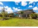 Lush backyard featuring a screened lanai, tropical landscaping, and a well-manicured lawn at 8265 Pavia Way, Bradenton, FL 34202