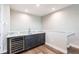 A modern bar area includes sleek gray cabinets, marble countertops, a mini-fridge and a stainless sink at 8265 Pavia Way, Bradenton, FL 34202