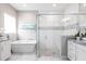 Bright bathroom featuring a soaking tub and glass shower with decorative tile at 8265 Pavia Way, Bradenton, FL 34202