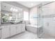Bright bathroom featuring a soaking tub, glass shower, and vanity with granite countertops at 8265 Pavia Way, Bradenton, FL 34202