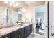 Bathroom featuring double sink, marble countertops, and elegant fixtures with an adjacent bedroom at 8265 Pavia Way, Bradenton, FL 34202