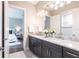 Bathroom featuring double sink, marble countertops, and elegant fixtures with an adjacent bedroom at 8265 Pavia Way, Bradenton, FL 34202