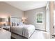 Bedroom with light-colored walls, a window, and a bed with decorative pillows at 8265 Pavia Way, Bradenton, FL 34202
