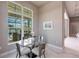 Cozy dining area with a modern glass table and seating, overlooking a screened pool area at 8265 Pavia Way, Bradenton, FL 34202