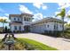 Elegant two-story home featuring a paver driveway, three-car garage, and lush landscaping at 8265 Pavia Way, Bradenton, FL 34202