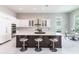 Bright kitchen with white cabinetry, granite countertops, stainless steel appliances, and breakfast bar seating at 8265 Pavia Way, Bradenton, FL 34202