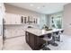 Well-appointed kitchen featuring an island with bar seating, white cabinetry, and stainless steel appliances at 8265 Pavia Way, Bradenton, FL 34202