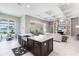 Spacious kitchen boasts an expansive island, stylish lighting, and views of the breakfast nook and living area at 8265 Pavia Way, Bradenton, FL 34202