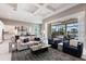 Open-concept living room with view to the kitchen, coffered ceiling, and a screened patio with pool view at 8265 Pavia Way, Bradenton, FL 34202