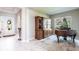 Living room showcasing an antique wooden cabinet, an upright piano, and bright foyer at 8265 Pavia Way, Bradenton, FL 34202