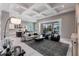 Open-concept living room with view to the kitchen, coffered ceiling, and a screened patio with pool view at 8265 Pavia Way, Bradenton, FL 34202