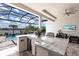 Outdoor dining with a marble bar overlooking pool and lake views at 8265 Pavia Way, Bradenton, FL 34202