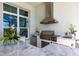The outdoor kitchen features a stainless steel grill, vent hood, and bar seating at 8265 Pavia Way, Bradenton, FL 34202