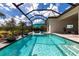 Beautiful pool with built-in lounge chairs and umbrella, surrounded by lush tropical landscaping at 8265 Pavia Way, Bradenton, FL 34202