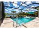 Screened-in pool area with clear blue water, lakeside views, and lounge chairs for relaxation at 8265 Pavia Way, Bradenton, FL 34202