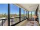Enclosed balcony with seating area and views of lush landscaping and nearby buildings at 8735 Midnight Pass Rd # 301B, Sarasota, FL 34242