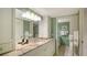 Bathroom with granite countertops, a sink, mirrors, and soft green walls provides a spa-like experience at 8735 Midnight Pass Rd # 301B, Sarasota, FL 34242