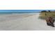 Expansive beachfront view with a bench, turquoise water and white sand at 8735 Midnight Pass Rd # 301B, Sarasota, FL 34242