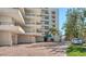 Exterior of condo featuring private balconies, brick drive, mature trees, and covered parking at 8735 Midnight Pass Rd # 301B, Sarasota, FL 34242