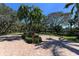 Beautiful landscaping features mature trees and brick-paved road throughout the Turtle Bay community at 8735 Midnight Pass Rd # 301B, Sarasota, FL 34242