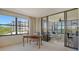 Bright living room features a desk, and glass sliding doors to an enclosed lanai with beautiful water views at 8735 Midnight Pass Rd # 301B, Sarasota, FL 34242