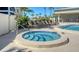 Relaxing hot tub area with lounge chairs near a swimming pool at 8735 Midnight Pass Rd # 301B, Sarasota, FL 34242