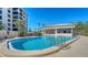 Stunning pool area with a spacious pool, lounge chairs, and a nearby building at 8735 Midnight Pass Rd # 301B, Sarasota, FL 34242